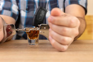 A glass of alcohol and car keys. The concept of driving under the influence of alcohol. clipart