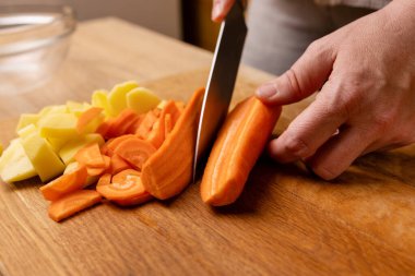 Çiğ havuç, bıçakla küp küp kesilir. Sebze yemeği hazırlama.