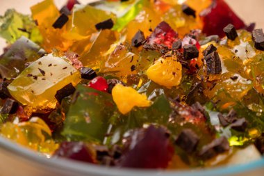 Çok renkli ezilmiş jelatin küpleri bir kasede karıştırılır. Jelatin tatlılarının hazırlanması.