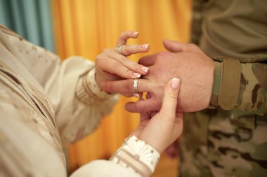 Gelin, damat için alyans takıyor. Savaş ve aşk.