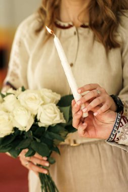 Gelin ve damat ellerinde yanan bir mum tutuyorlar..