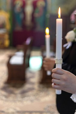 Gelin ve damat bir kilise düğününde ellerinde mum tutarlar..
