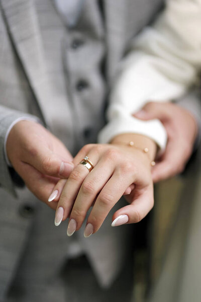 Жених держит невесту за руку обручальным кольцом. Свадебные церемонии.