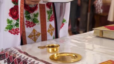 Rahip elinde bir haç ve elinde bir kitapla dua okur..