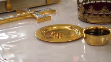 Alyansları, taçları ve kilisedeki bir haçı olan bir yer..