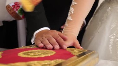 Kilise düğünü sırasında, yeni evliler ellerini İncil 'e koydular ve evlilik yemini ettiler..