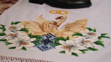 Bir kilise düğünü sırasında, yeni evliler geleneksel işlemeli bir havlunun üzerinde dururlar..
