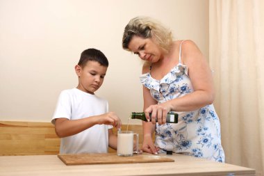 Anne ve oğlu pizza hamuru hazırlıyor. Evde yemek pişirmek..