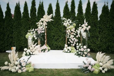 Düğün seremonisi için çimenlikte çiçek kemeri.