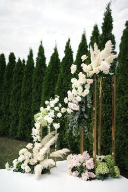 Düğün seremonisi için çimenlikte çiçek kemeri.