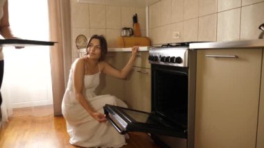 Bir kadın ve kızı fırına pizza pişirmek için pizza koydu. Evde pizza pişirmek..