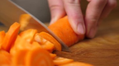 Çiğ havuç, bıçakla küp küp kesilir. Sebze yemeği hazırlama.