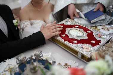 Gelin ve damat ellerini İncil 'e koyup evlilik yeminlerini ettiler..