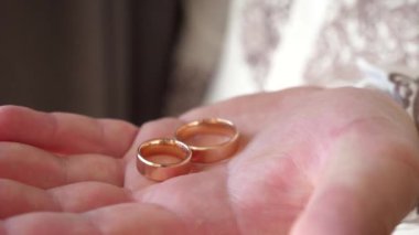 Adamın elinde iki tane altın alyans var. Düğün hazırlıkları..