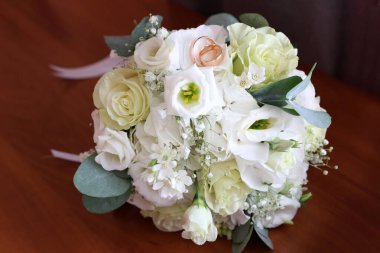 Güzel bir beyaz buket ve iki altın alyans. Düğün hazırlıkları..