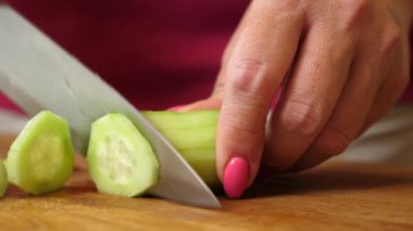 Salatalık bıçakla daireler çizer. Sebze yemekleri hazırlama.