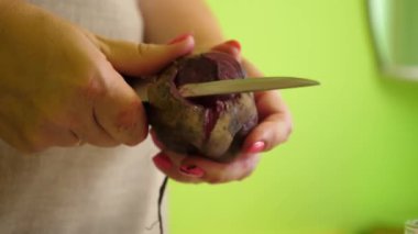 Bir kadın sebzeleri bıçakla temizler. Sebzelerden yemek pişirme.