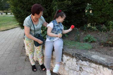 Down sendromlu bir anne kızıyla birlikte yürüyor..