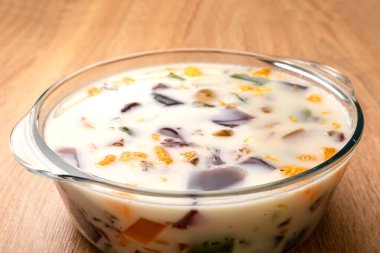 Jelatin küpleri süt ve yoğurtla karıştır. Jelatin tatlılarının hazırlanması.