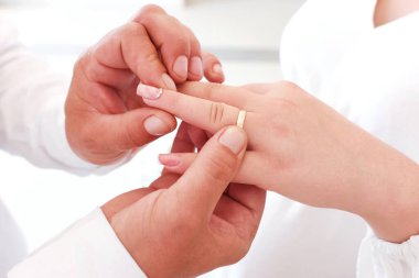 Damat gelinin altın alyansını parmağına takar. Düğün töreni..