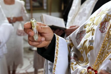 Rahip vaftiz törenini ve kutsama törenini gerçekleştirir..