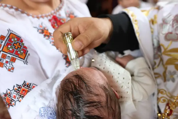 Rahip vaftiz törenini ve kutsama törenini gerçekleştirir..
