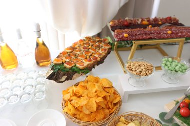 Patates cipsi, fındık ve sandviçli büfe masası..