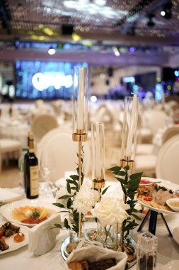 Tabaklar ve içeceklerle dolu festival masası mumlar ve çiçeklerle süslenmiştir..