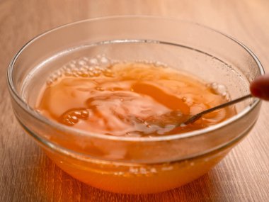 Portakal reçelini bir kasede erit. Jelatin tatlılarının hazırlanması.