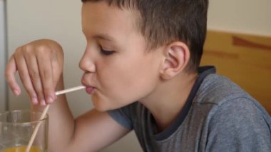 Anne ve oğul masada otururken meyve suyu içerler..