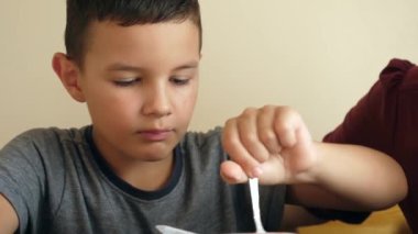 Bir çocuk ve annesi mutfakta yoğurt yiyorlar..