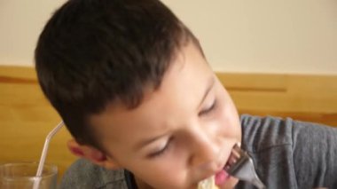 Bir çocuk ve annesi mutfakta yoğurt yiyorlar..