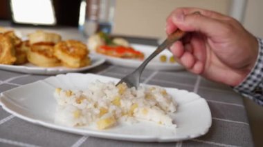 Masadaki tabaktan pirinç lapası yiyorlar..