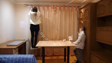 Bir kız ve küçük erkek kardeşi doğum günü için bir oda dekore ediyorlar. 