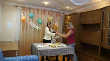 Bir anne, kızı ve oğluyla birlikte doğum günü kutlaması için şenlik masasına servis yapıyor..