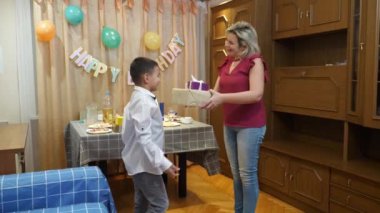 İnsanlar çocuğu doğum gününde kutluyor ve hediyeler veriyor..