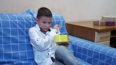 Bir çocuk doğum gününde ona verilen hediyeleri açar..