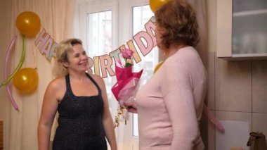 İnsanlar bir kadını doğum gününde tebrik eder ve hediyeler verir. Doğum günü kutlaması.