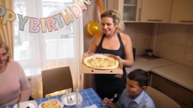 Bir kadının doğum gününü kutlayan insanlar masaya oturur, içer ve kendilerini ödüllendirirler. Doğum günü kutlaması.