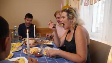 Bir kadının doğum gününü kutlayan insanlar masaya oturur, içer ve kendilerini ödüllendirirler. Doğum günü kutlaması.