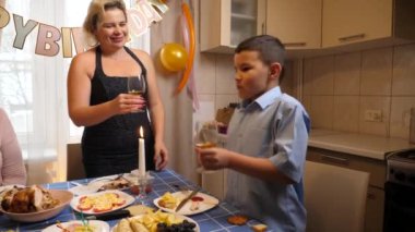 Bir kadının doğum gününü kutlayan insanlar masaya oturur, içer ve kendilerini ödüllendirirler. Doğum günü kutlaması.