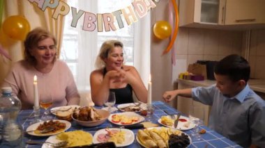 Bir kadının doğum gününü kutlayan insanlar masaya oturur, içer ve kendilerini ödüllendirirler. Doğum günü kutlaması.