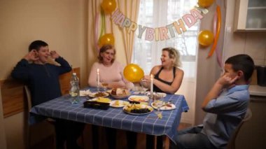 Bir kadının doğum gününü kutlayan insanlar masaya oturur, içer ve kendilerini ödüllendirirler. Doğum günü kutlaması.