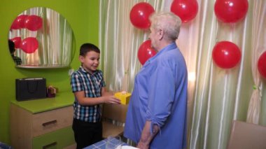 Kızlar ve torunlar büyükannelerini doğum günü için kutlarlar ve hediyeler verirler. Doğum günü kutlaması.