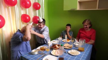 Büyükannenin doğum gününü kutlayan konuklar masaya oturur, içer ve kendilerini ödüllendirirler. Doğum günü kutlaması.