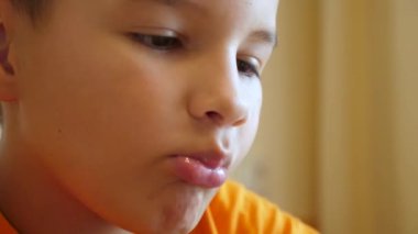 Bir çocuk masada otururken bir muz yer..