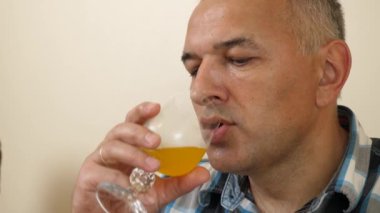 Bir adam masada otururken soda içer..