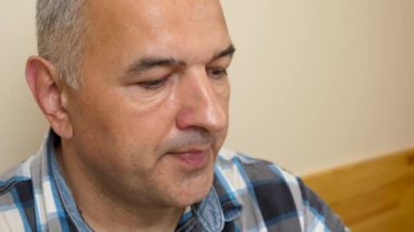 Bir adam masada otururken soda içer..