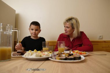 Festival masasında, anne ve oğluna yiyecek ve içecek ikram edilir..