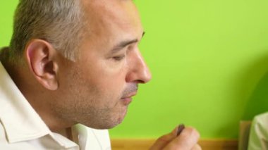 Bir adam masada otururken borş yer. Ev yemekleri..